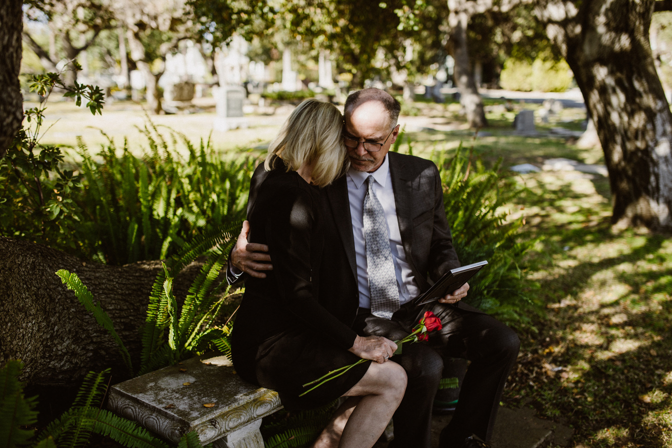 Mourning Couple Sitting on Concrete Bench 